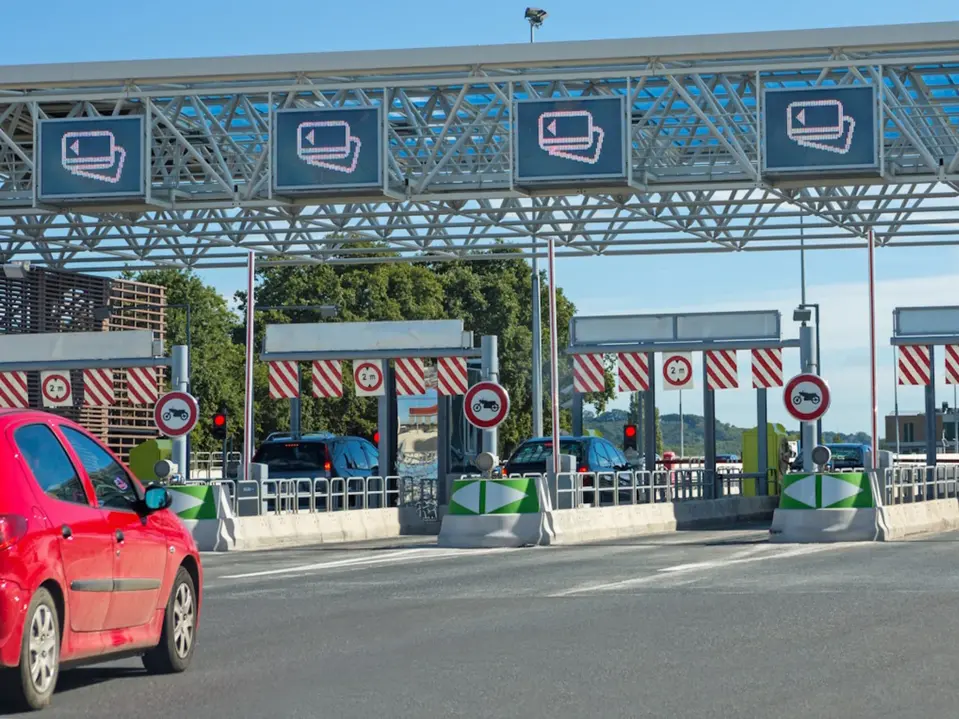 Rotes Auto vor einer Mautstation