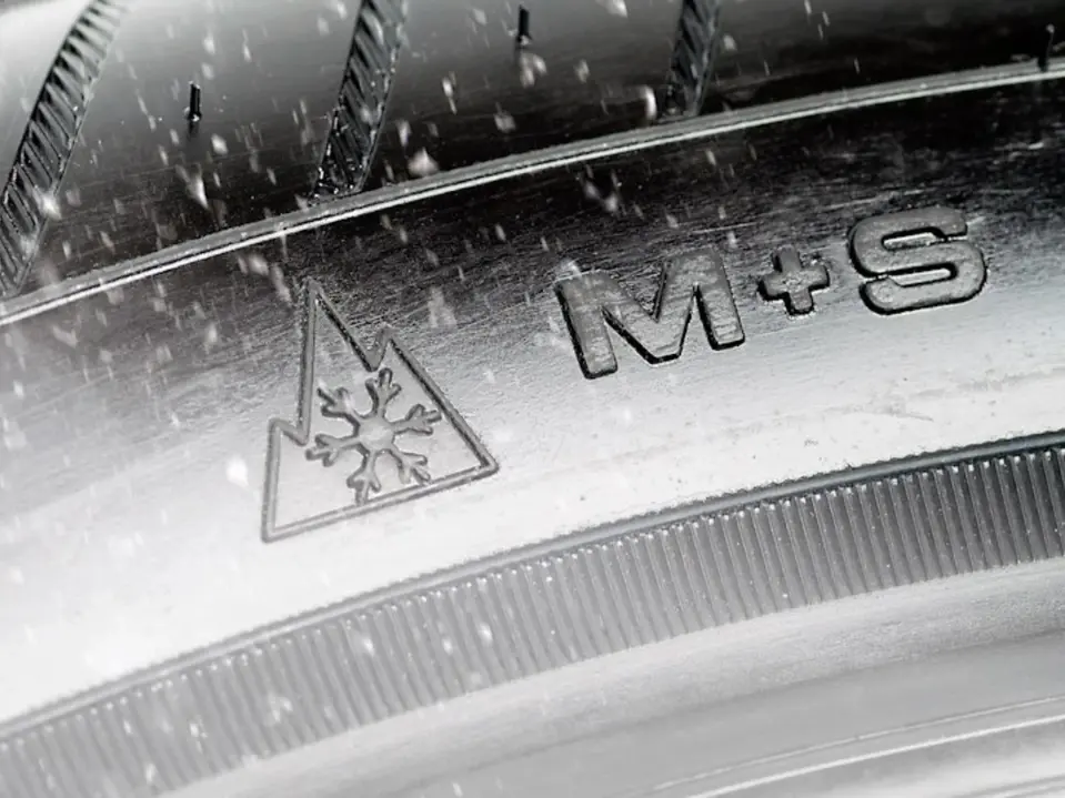Ausschnitt eines Autoreifens mit M+S Symbol