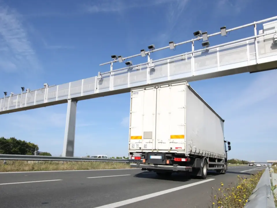 LKW fährt unter Mautbrücke auf Autobahn hindurch