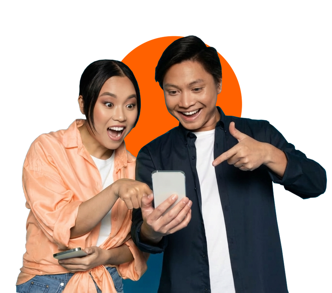 Two people smiling while looking at a mobile phone, with one pointing at the screen against an orange circle background.