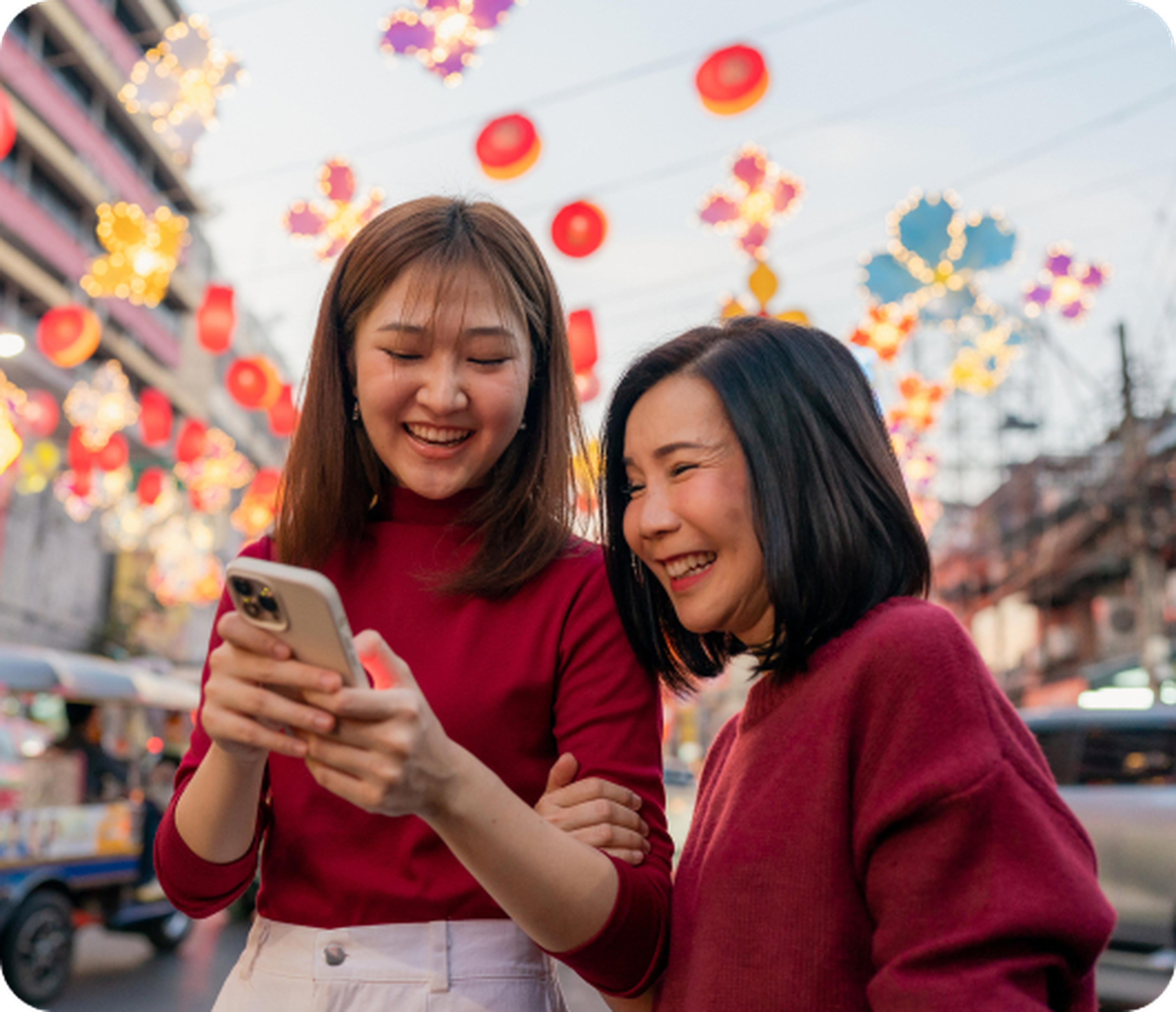 Mother and daughter smiling at their phone