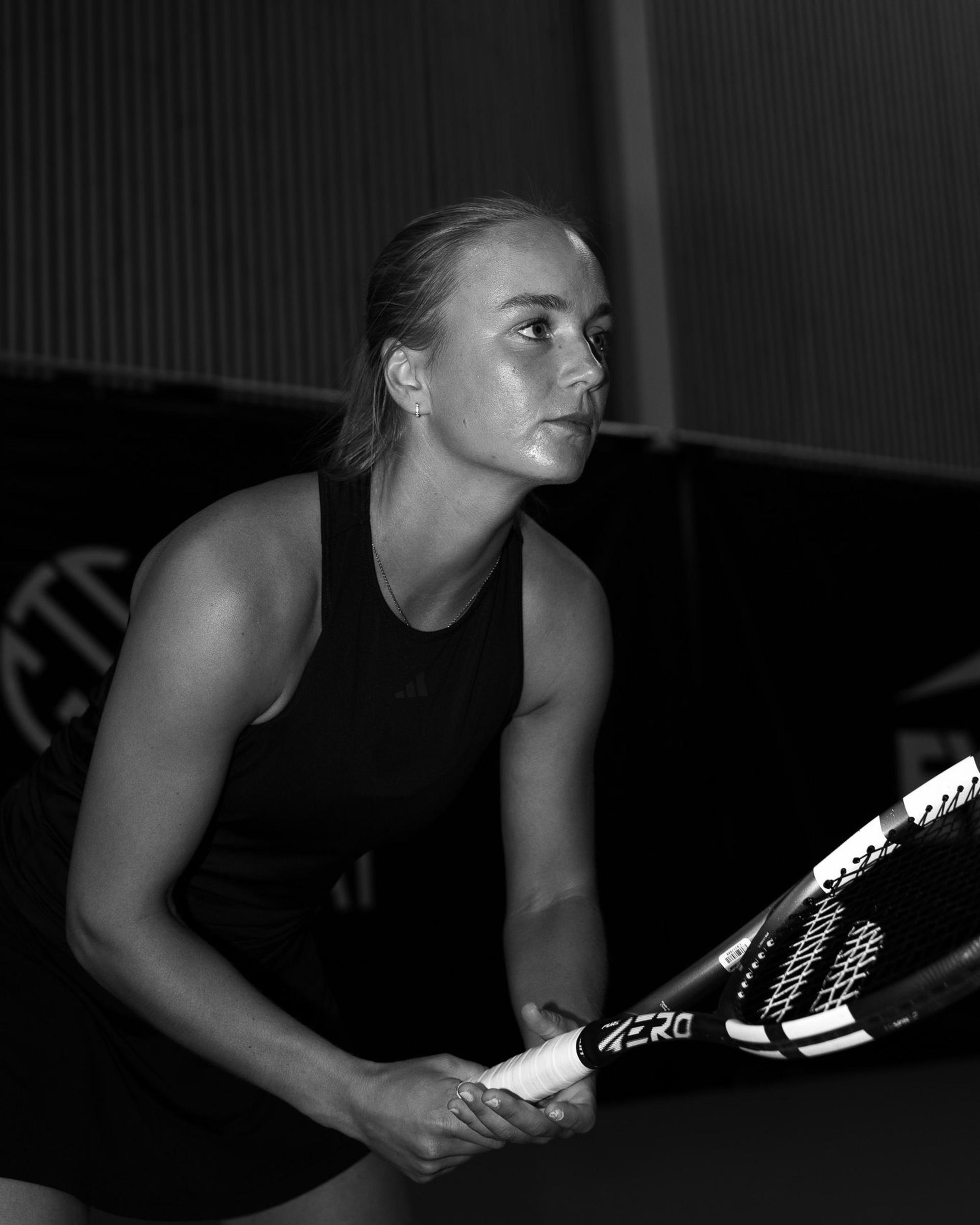 Black and white image of a tennis player preparing a shot with her racket
