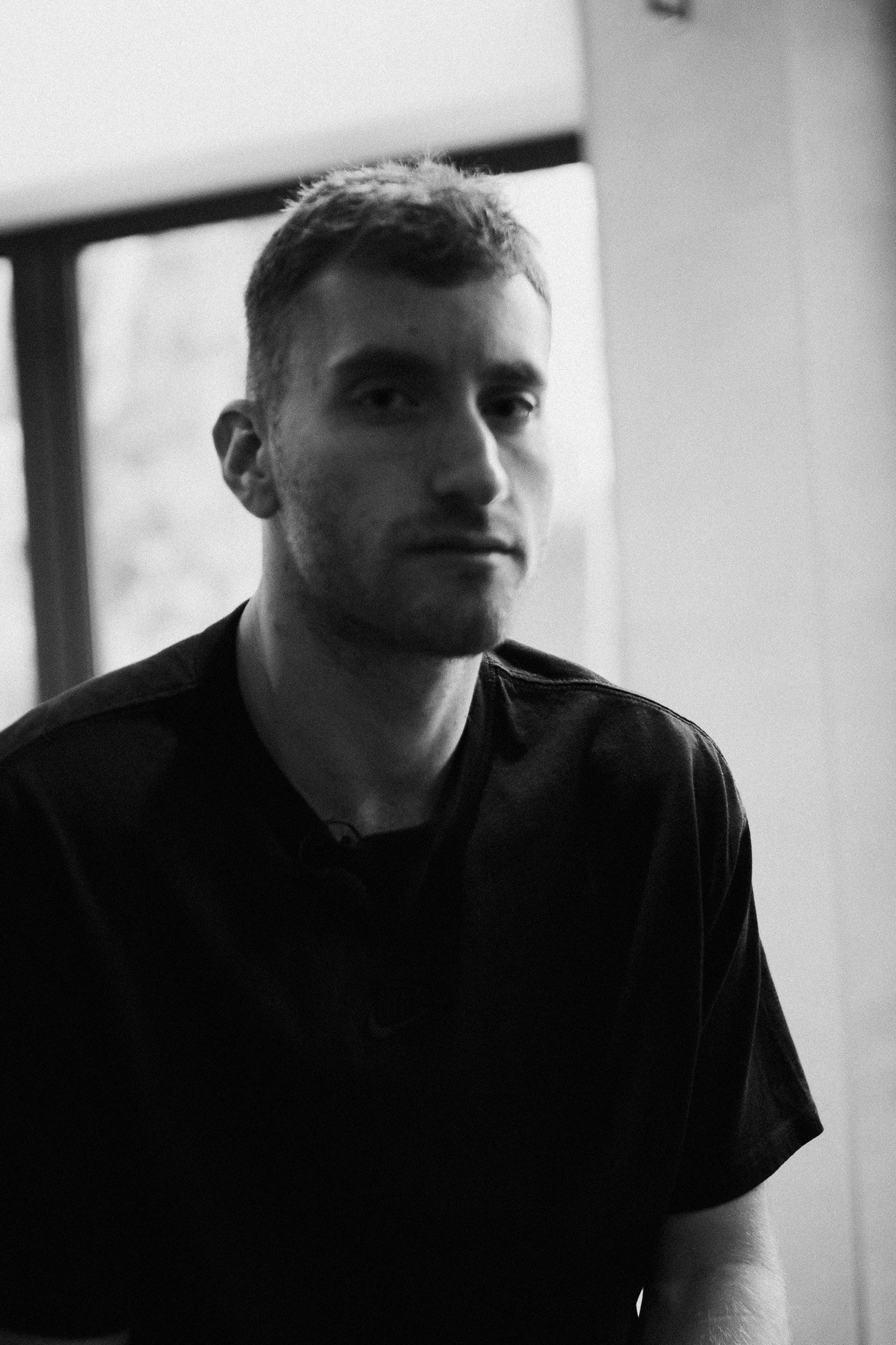 Black and white portrait of a footballer seated by a window