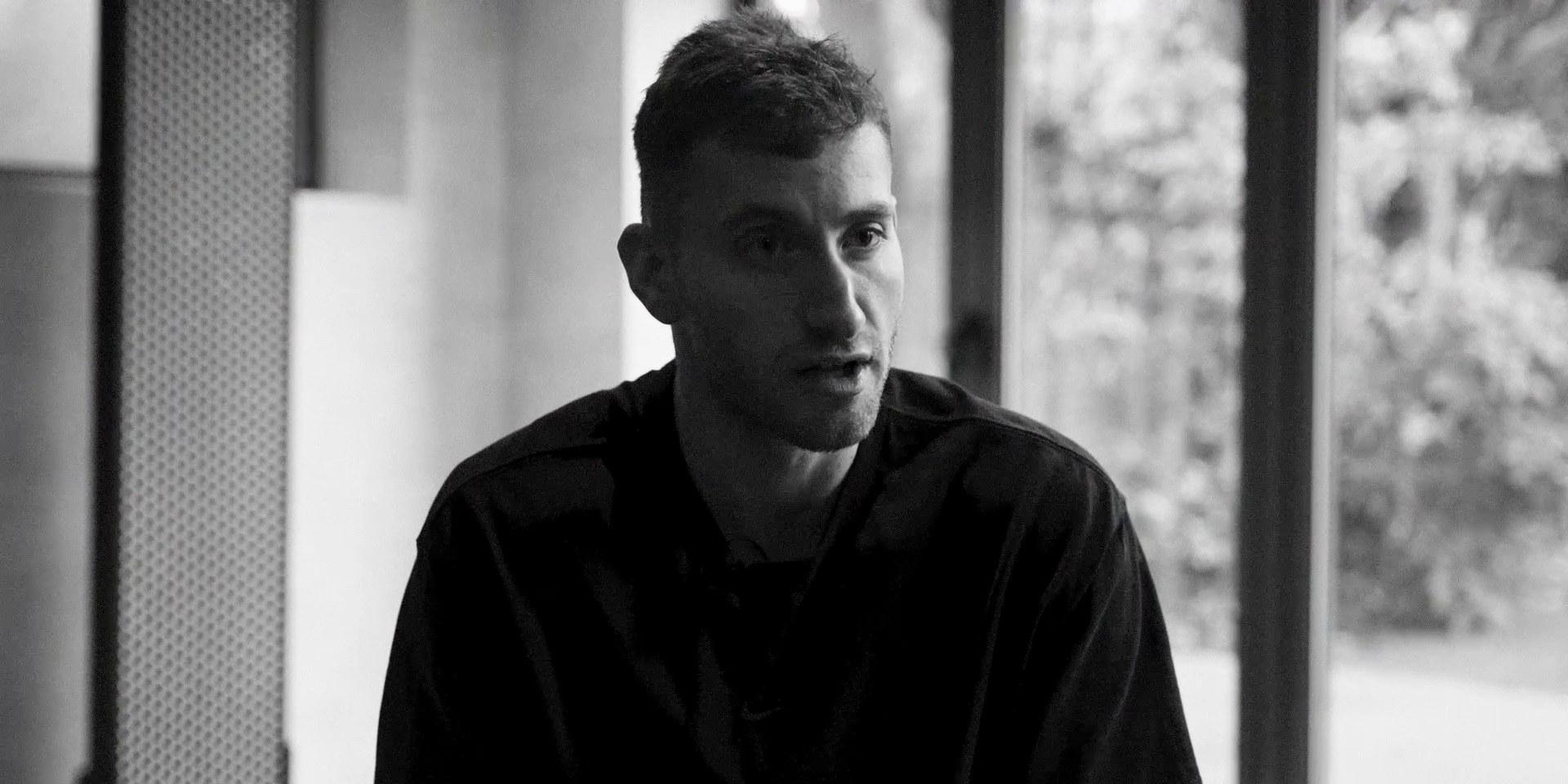 Black and white image of a footballer seated by a window during an interview