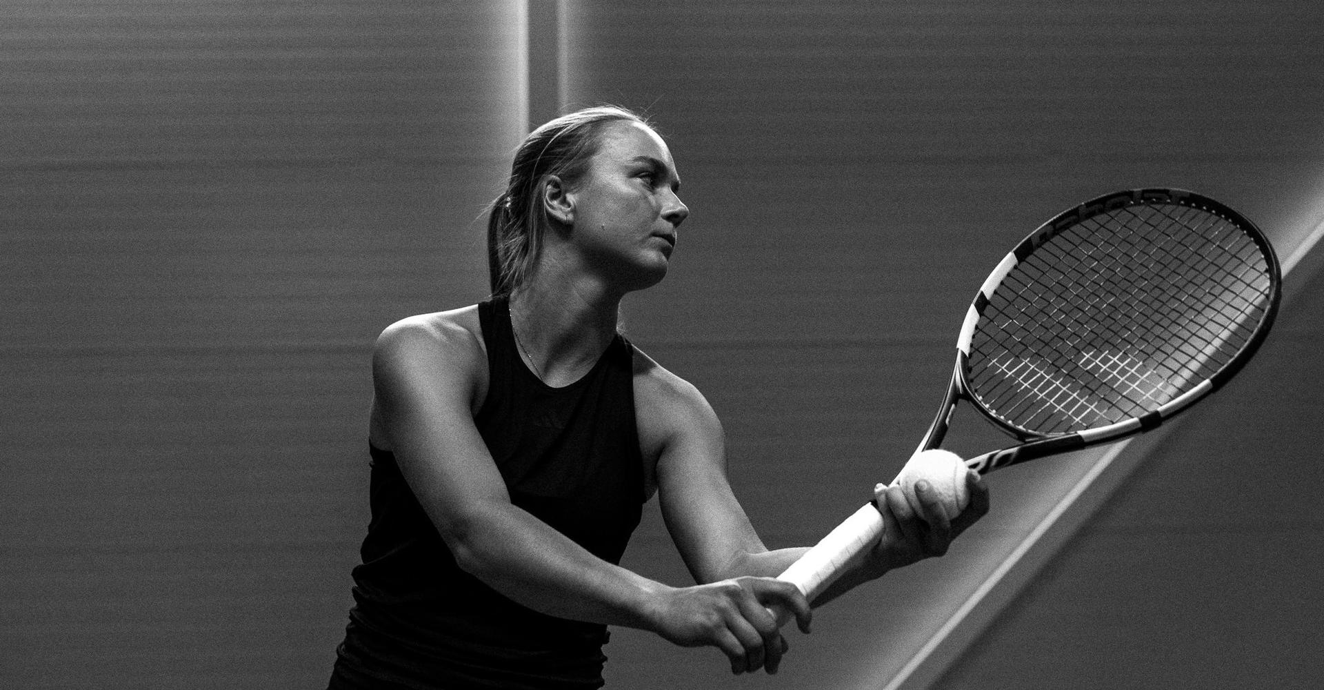 Black and white image of a tennis player preparing a shot with her racket