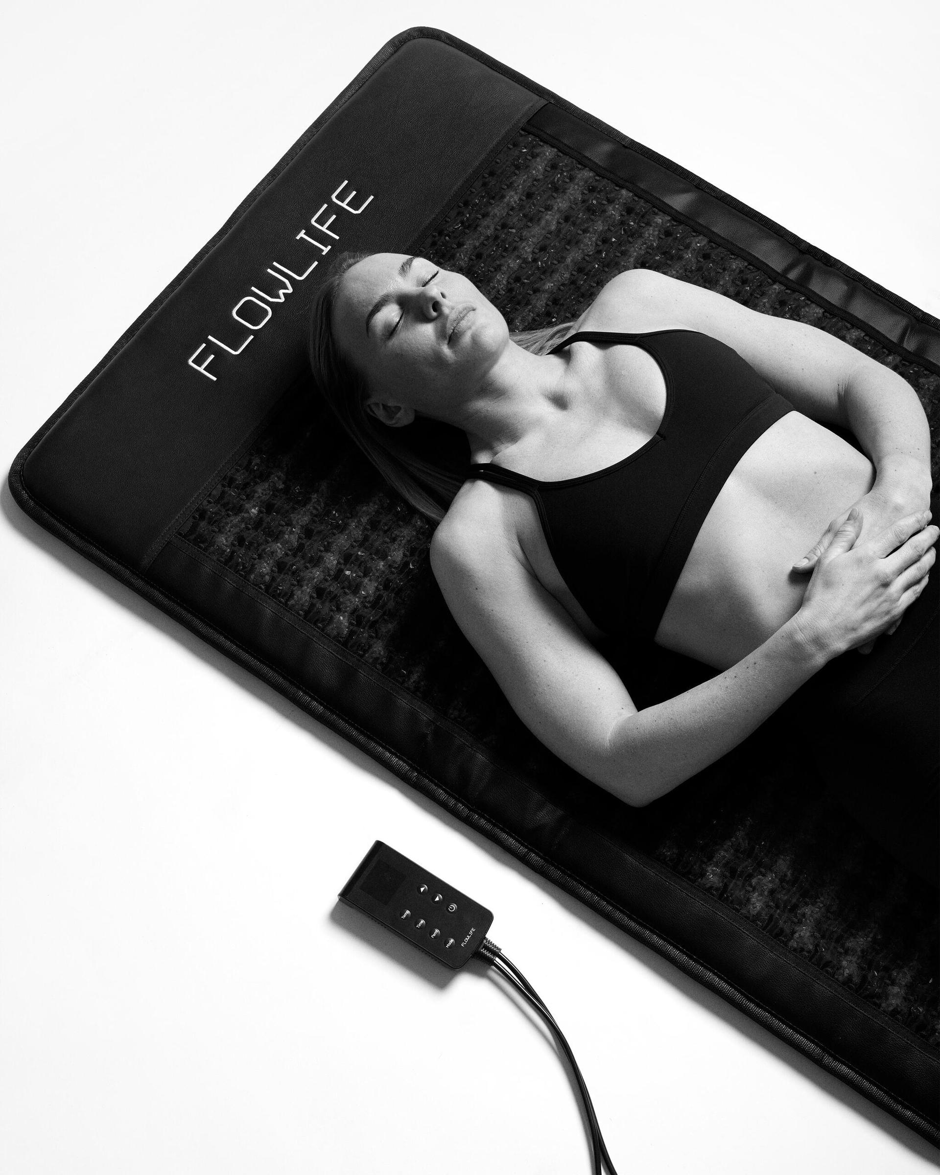 Person lying on Flowpemf IR Mat Pro