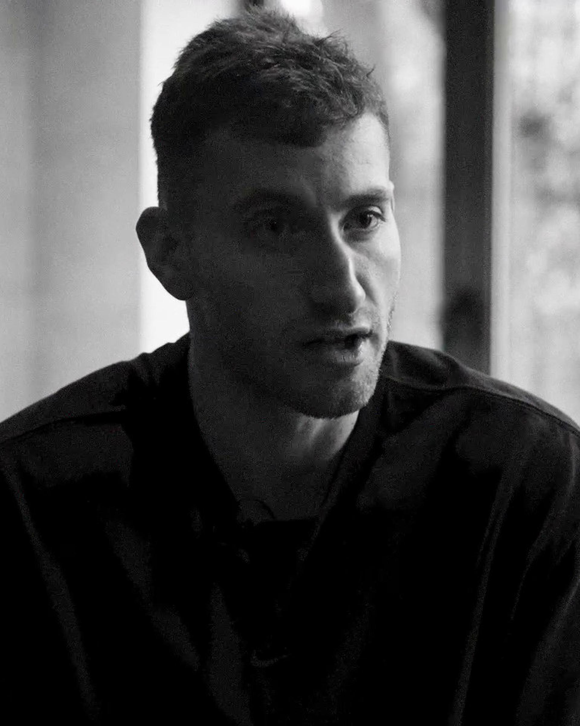 Black and white image of a footballer seated by a window during an interview