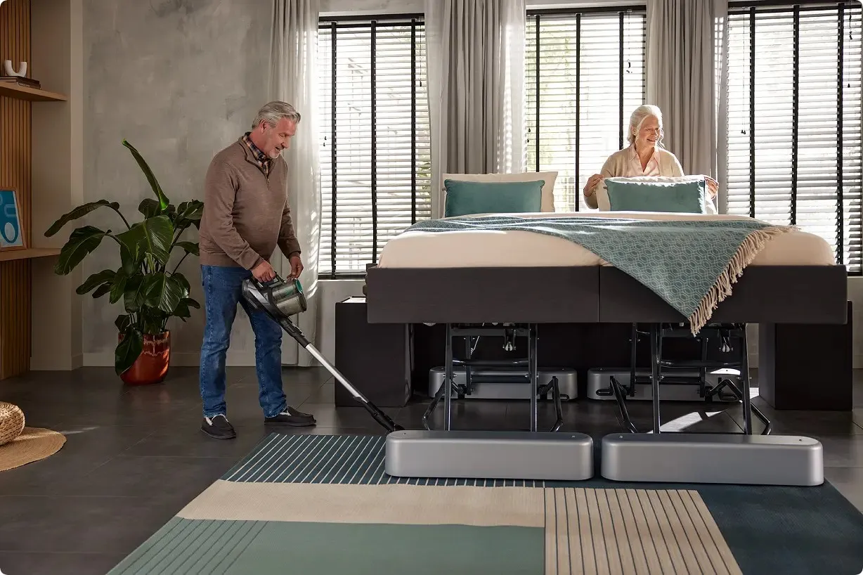 Man stofzuigt onder hoog-laagbed
