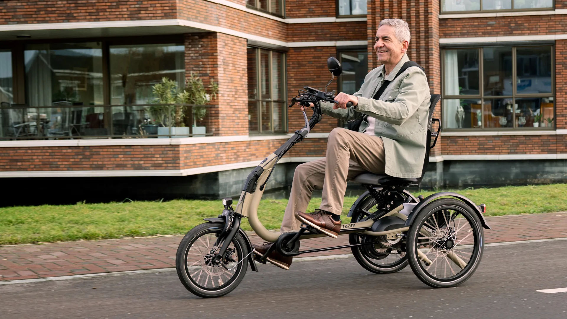Lachende meneer fietst op een driewieler