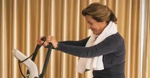 vrolijke vrouw op fitnessapparaat