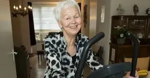 vrolijke oudere vrouw op een hometrainer