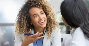vrouw als zorgprofessional in gesprek met iemand anders