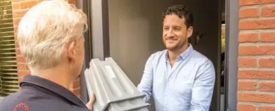 Bezorger van Medipoint brengt bedklossen bij persoon aan huis