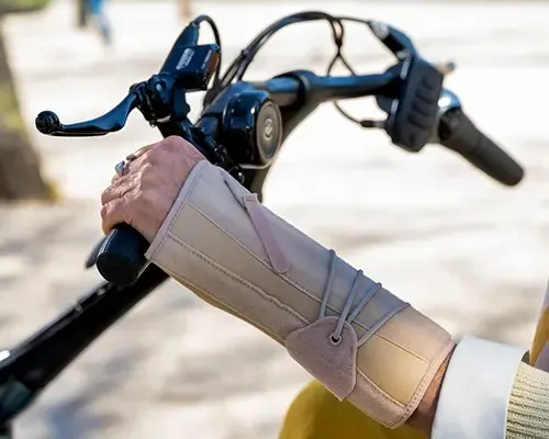vrouw op de fiets met brace om de pols