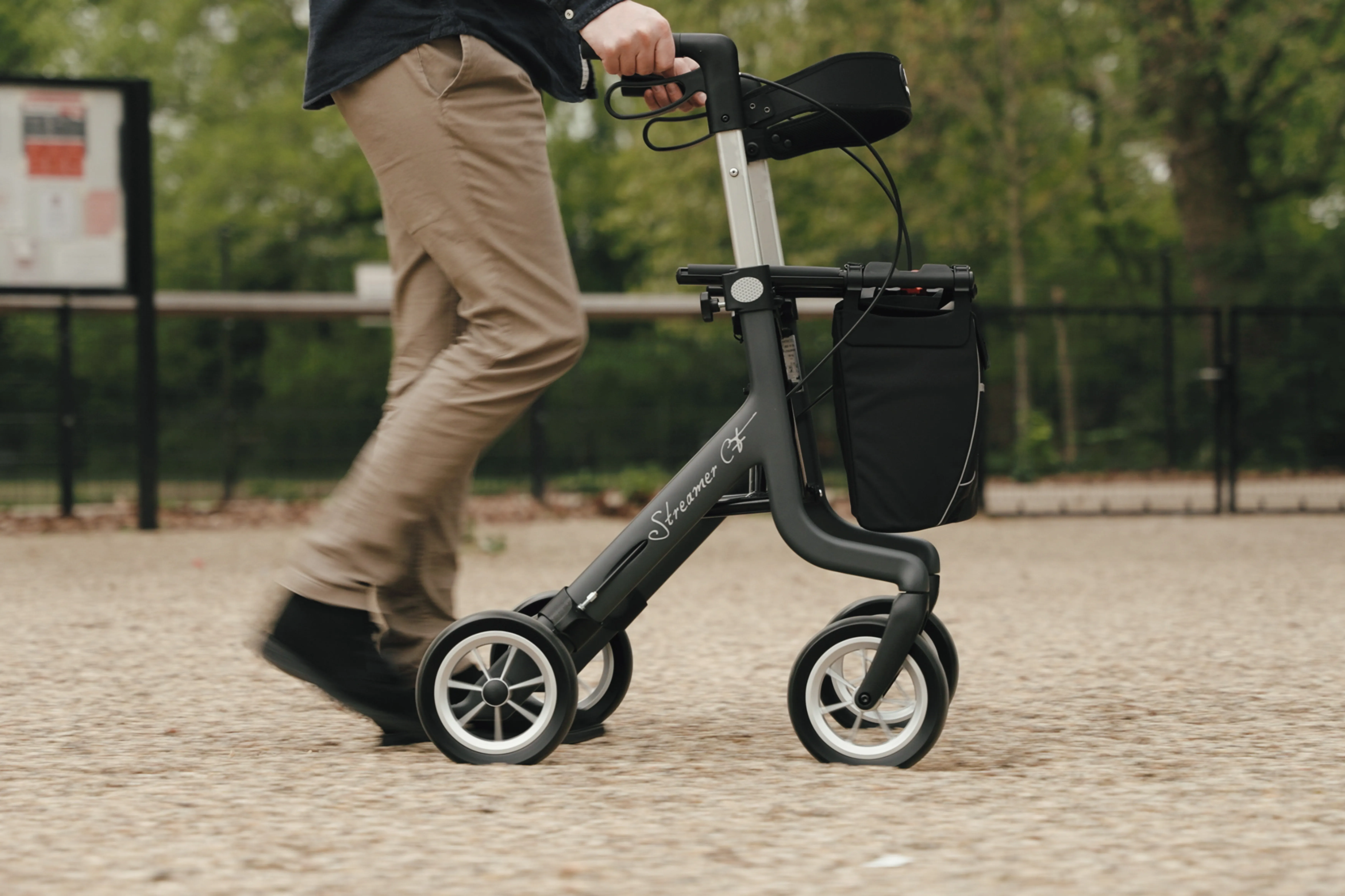 Man loopt met de Streamer rollator door een park