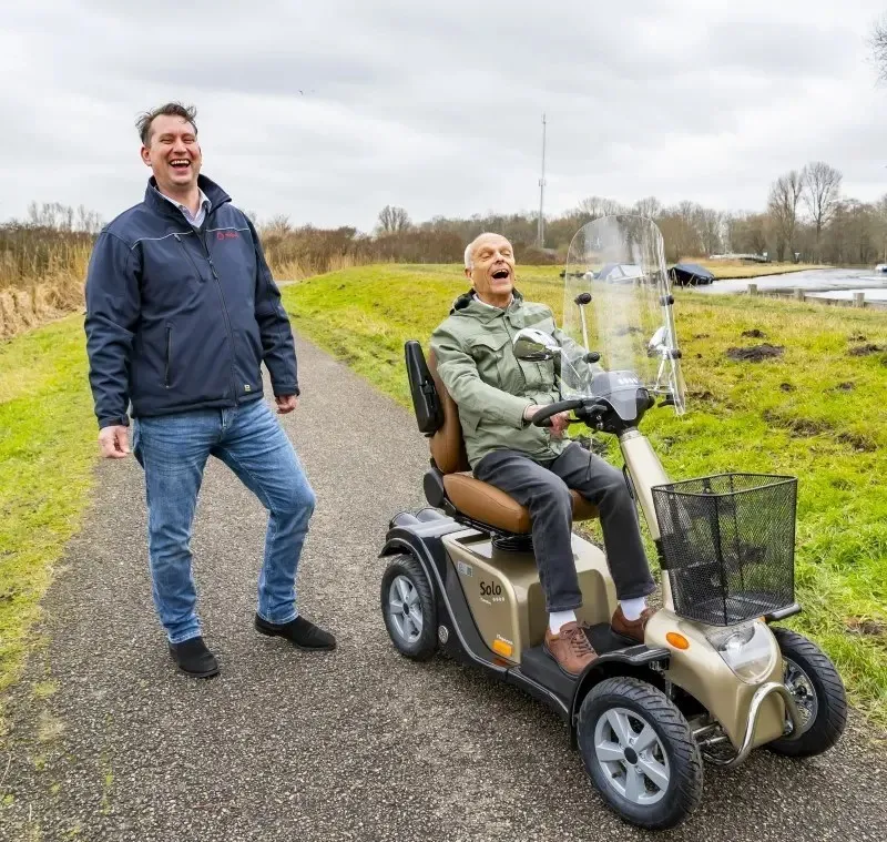 Medipoint klant zit lachend in zijn scootmobiel
