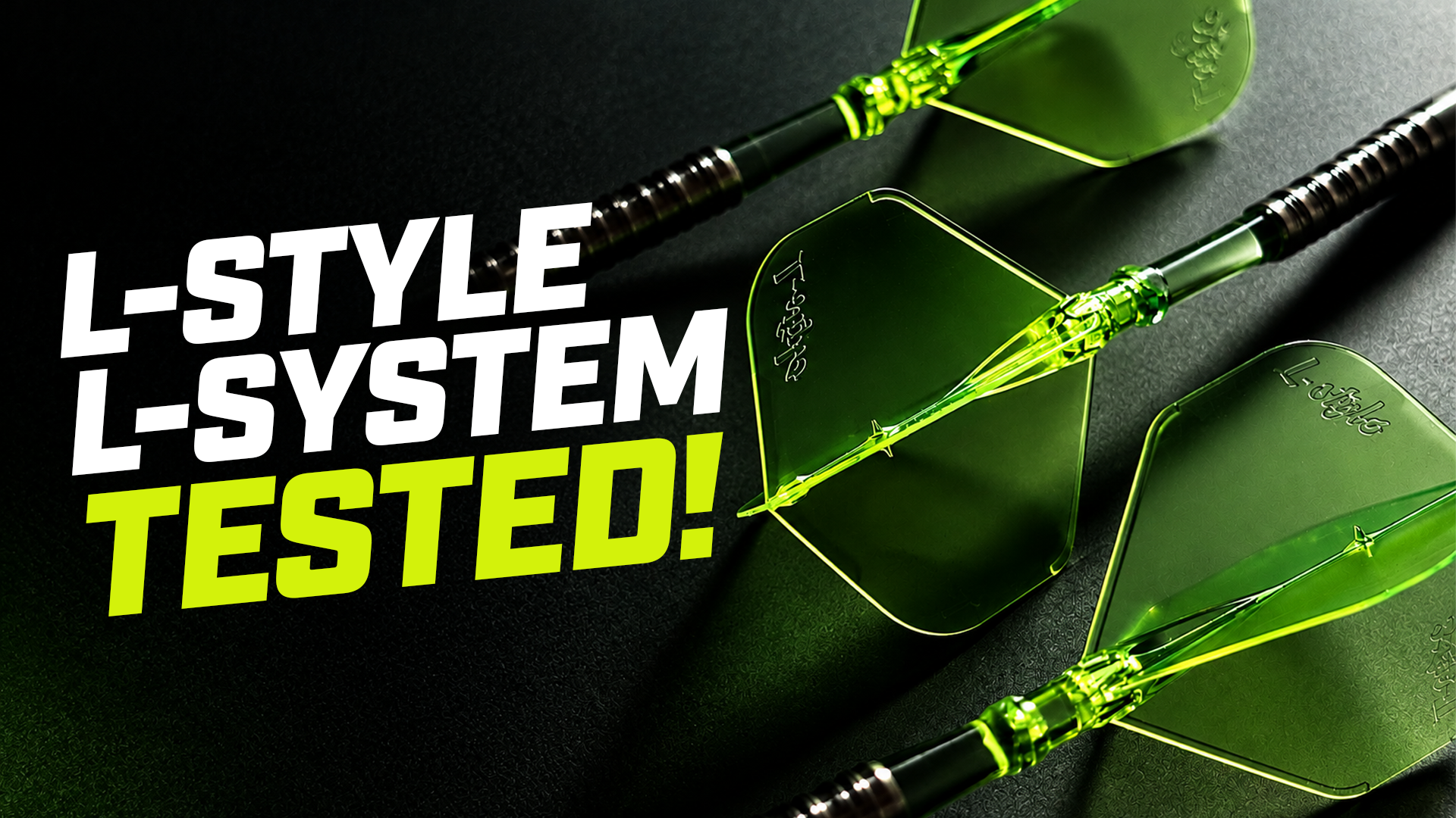 Three green dart flights with black shafts on a dark surface. Text reads, "L-STYLE L-SYSTEM TESTED!" in bold white and yellow letters.