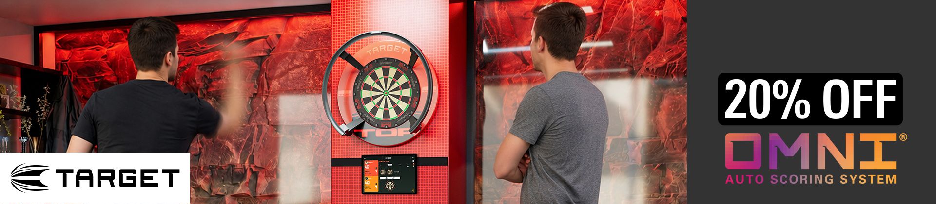 Two people playing darts in a room with red lighting, featuring a TARGET dartboard and a 20% off offer for the OMNI auto scoring system.