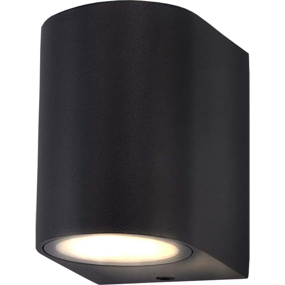 Black cylindrical wall sconce with a downlight, mounted on a white background, emitting a soft white glow.