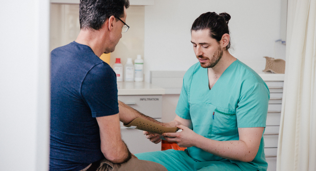 Lachende Kinder und ihre Mütter bei einem Besuch im Krankenhaus, um einen Teddybären zu untersuchen.