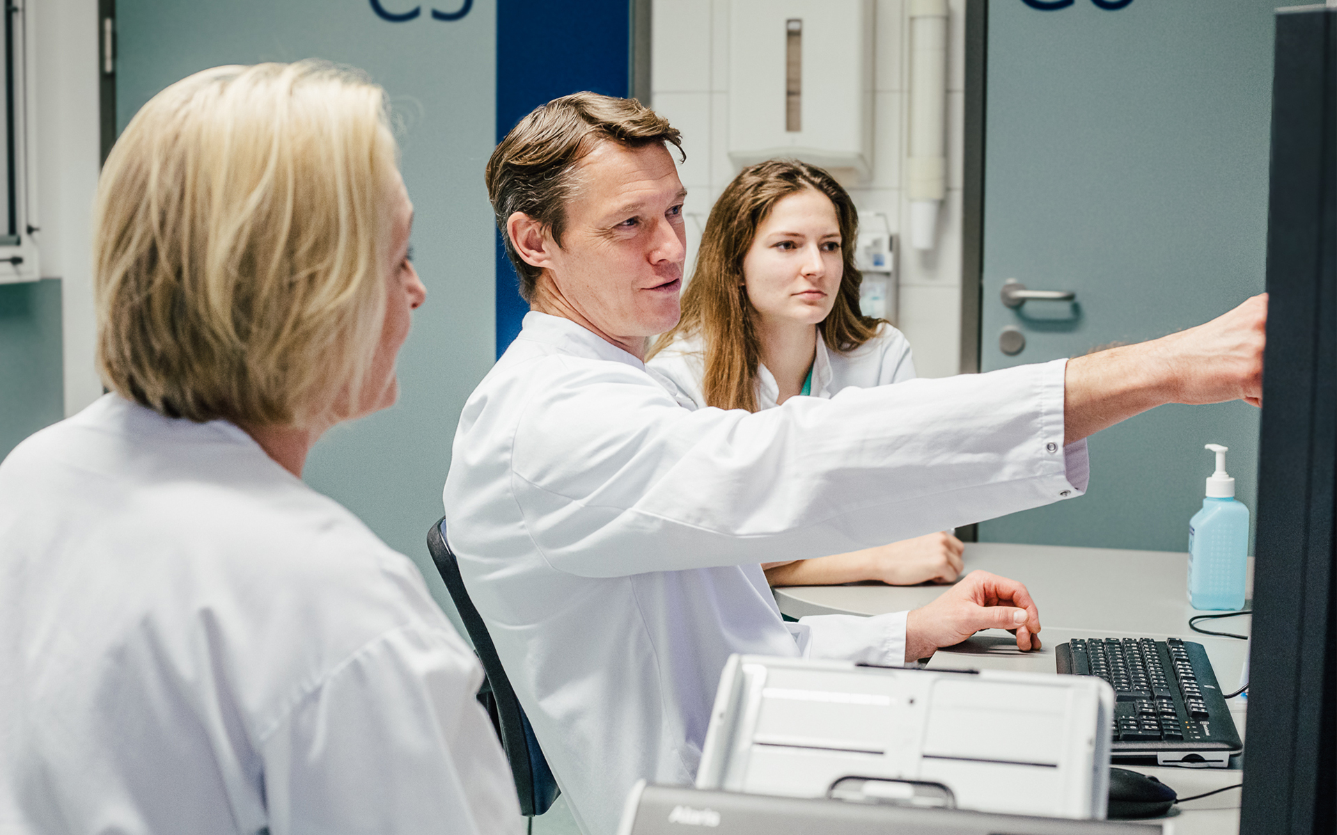 Eine Ärztin zeigt einer lächelnden Patientin Befunde auf einem Tablet.