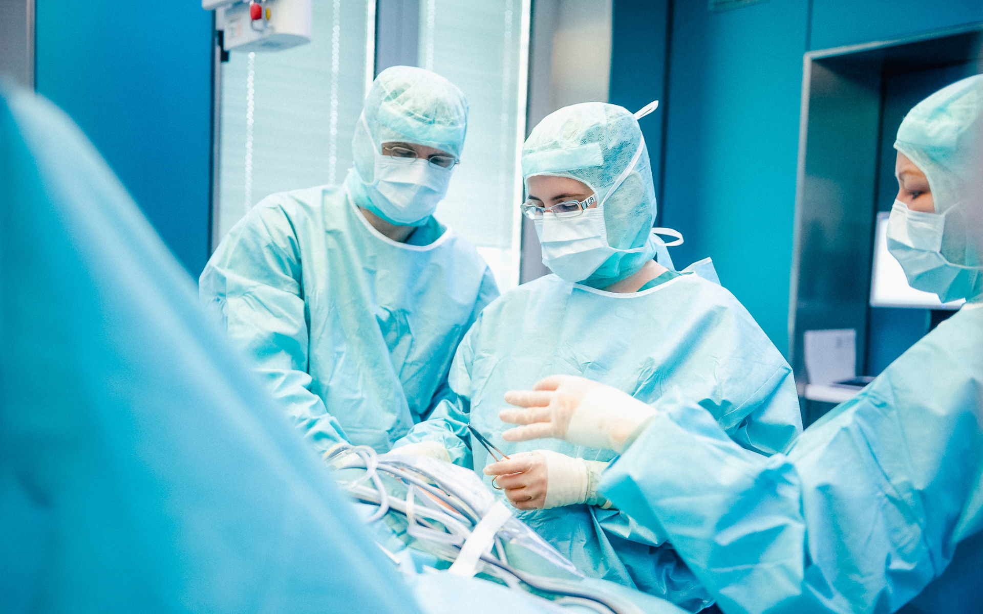 Mehrere Chirurg*innen arbeiten konzentriert zusammen und führen eine Operation in der Tagesklinik durch.