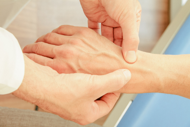 Ein Arzt untersucht die Hand eines Patienten