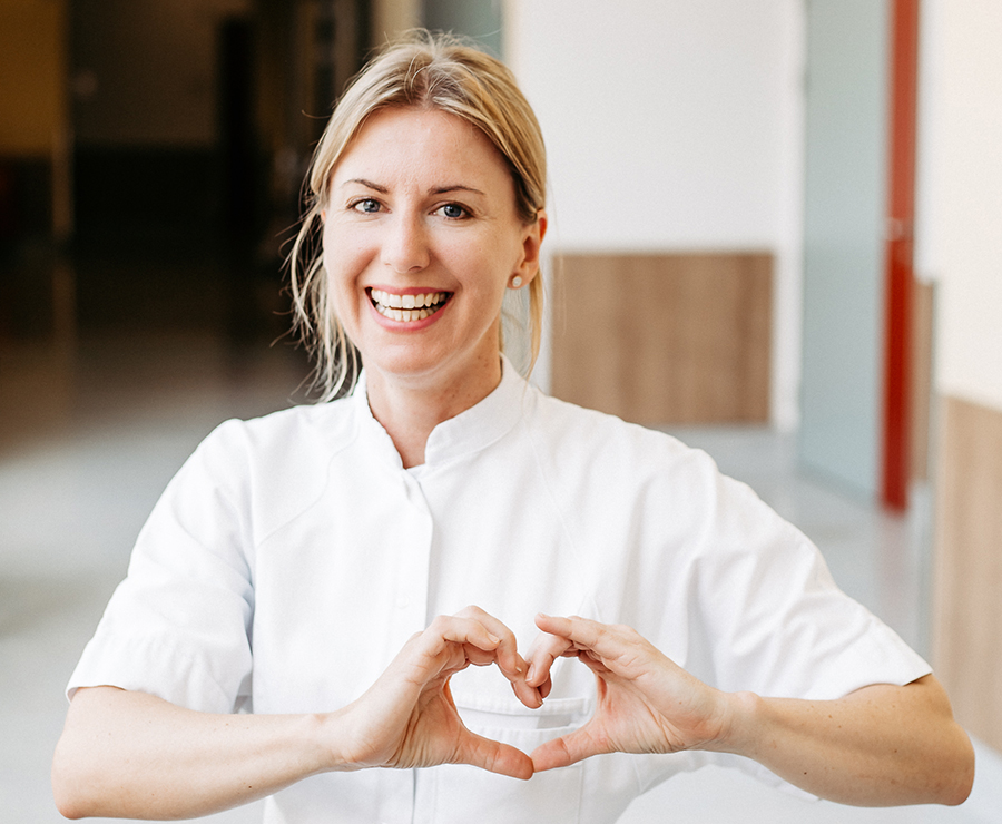 Eine Mitarbeiterin formt mit den Händen ein Herz