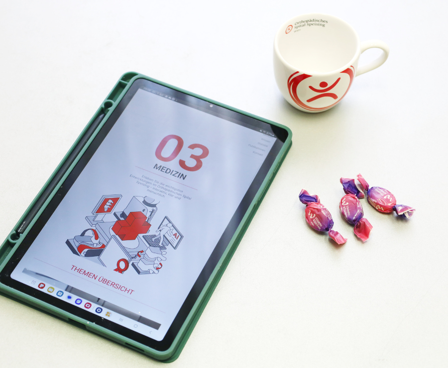 Tablett auf Tisch mit Jahresbericht, Tasse und Zuckerl daneben
