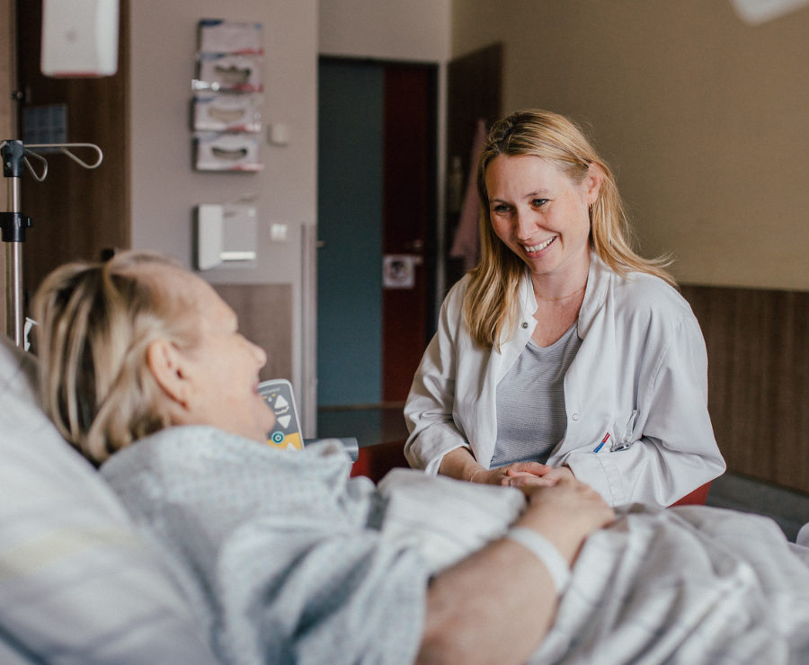Seelsorgerin spricht mit Patientin. 