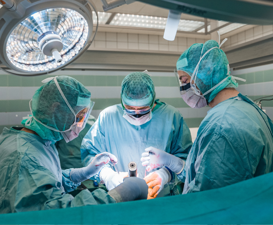 Ein hochkonzentriertes Operationsteam führt in einem modern ausgestatteten OP-Saal einen orthopädischen Eingriff durch.