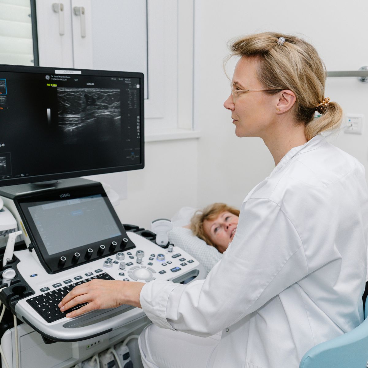 Eine Ärztin macht einen Brustunterschall bei einer Patientin.