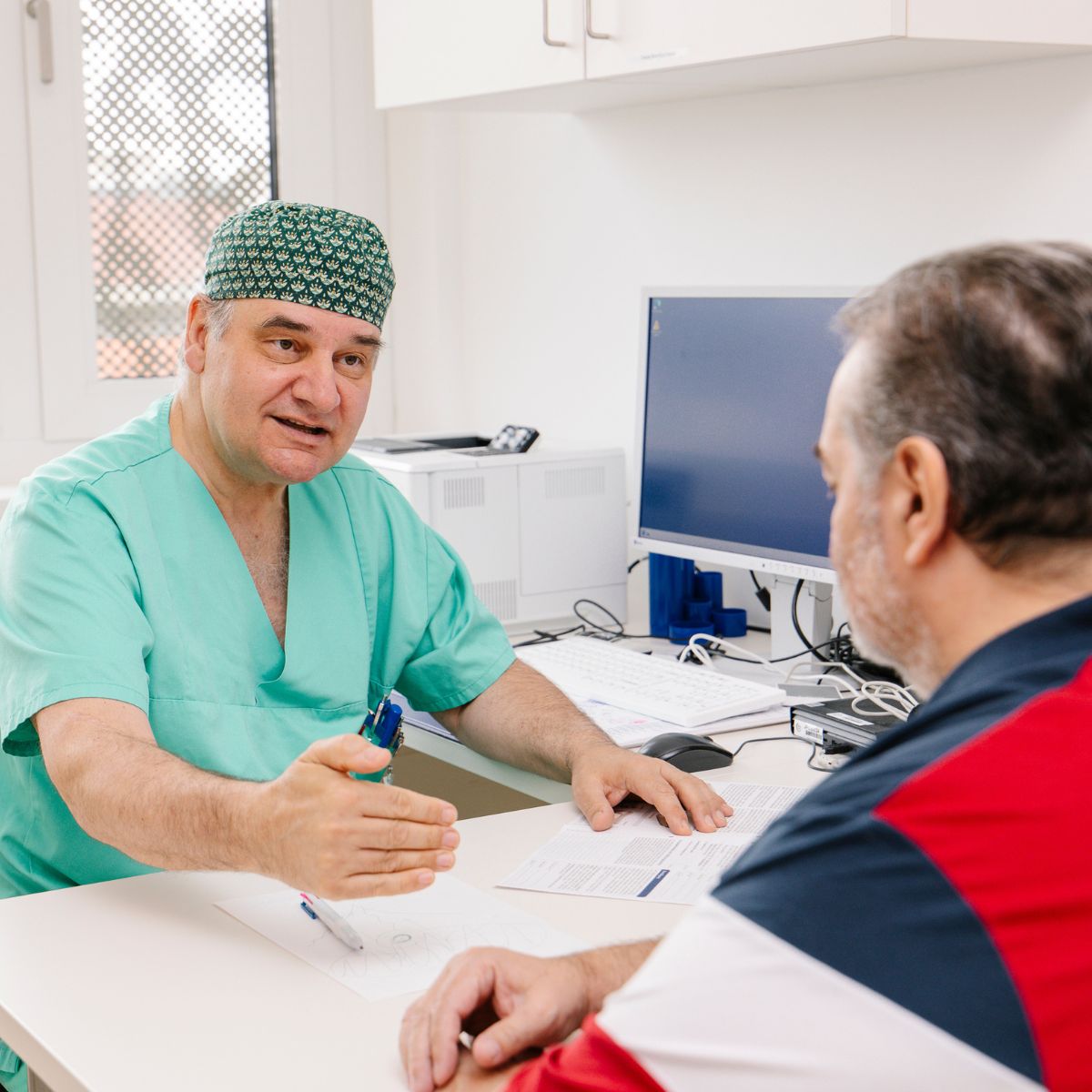 Ein Chirurg im Gespräch mit einem Patienten.
