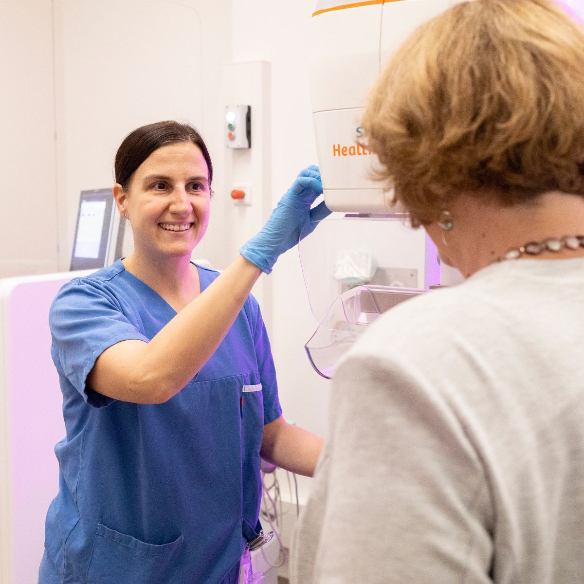 Eine Radiotechnologin bedient das Röntgengerät, mit dem bei einer Patientin eine Mammografie durchgeführt wird.