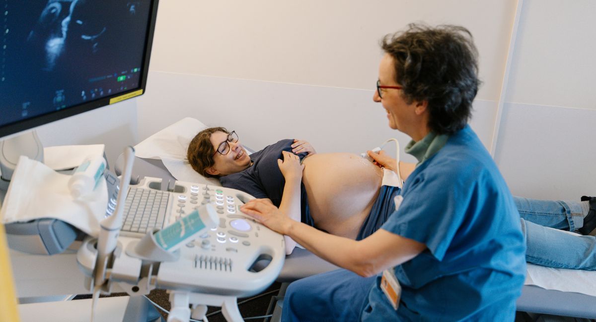 Eine Ärztin führt eine Ultraschallkontrolle bei einer Schwangeren durch.