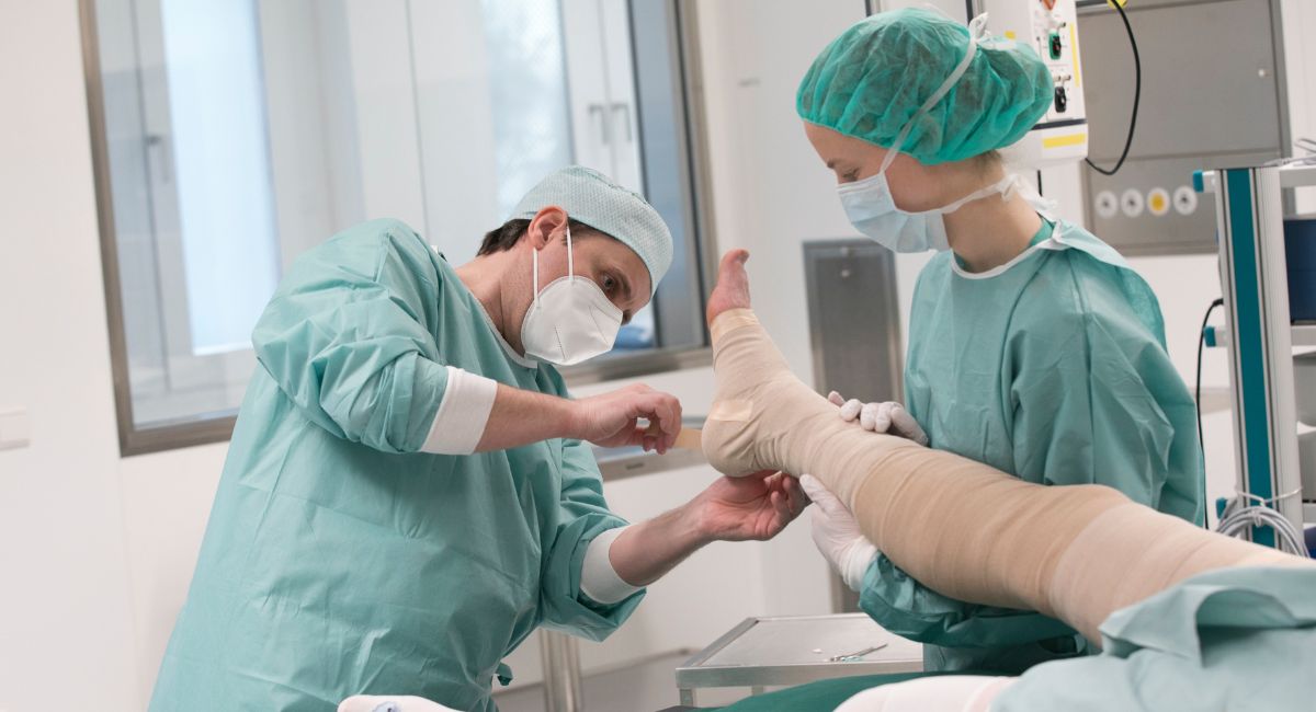 Arzt verbindet das Bein eines Patienten