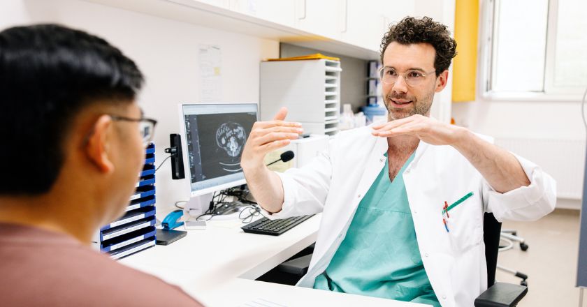 Ein Arzt erklärt einem Patienten etwas mit den Händen.
