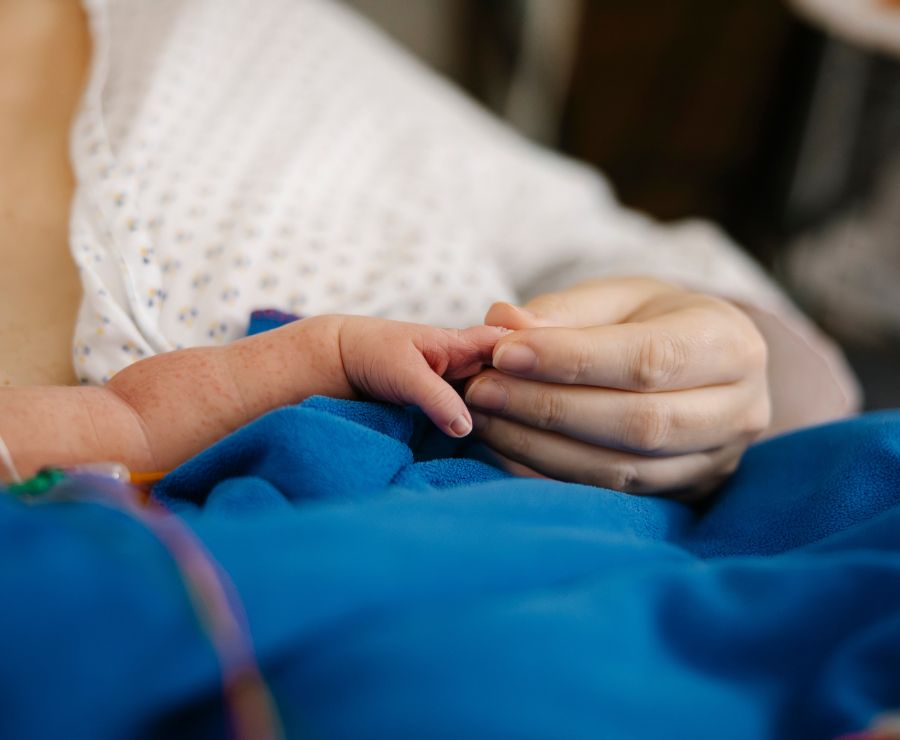 Eine Mutter hält die Hand ihres Babys.