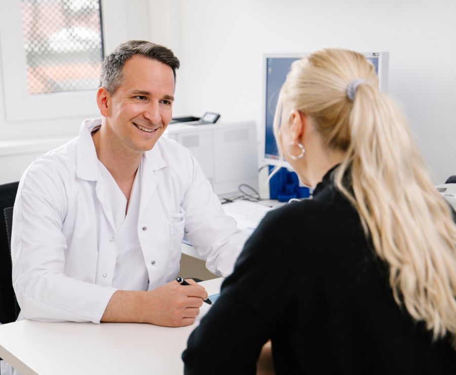 Der Primar der Gynäkologie führt mit einer Patientin ein Gespräch.