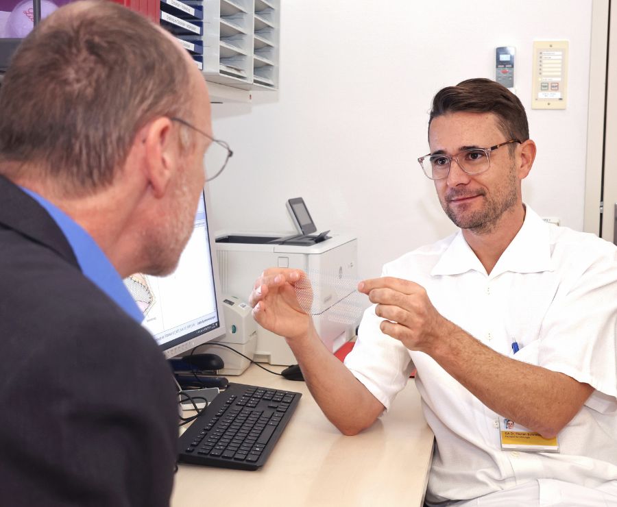 Ein Arzt erklärt einem Patienten einen Eingriff.