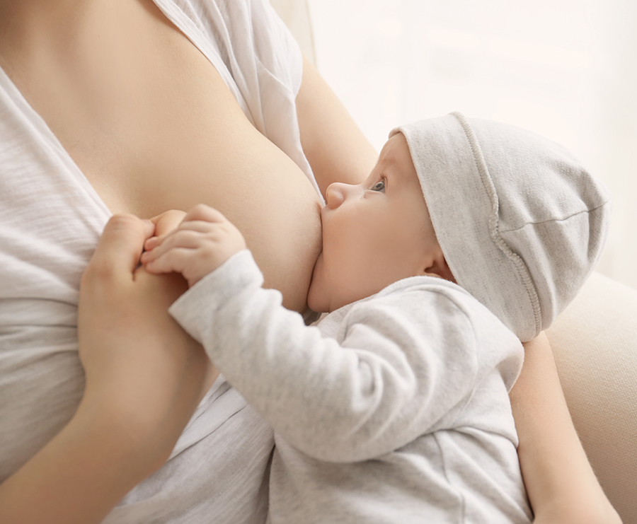 Ein Baby trinkt an der Brust seiner Mutter.