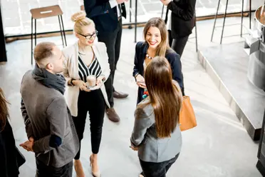 Personen in Business Kleidung unterhalten sich auf einer Veranstaltung.