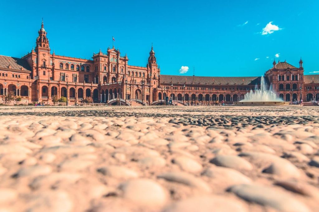 Die roten Gebäude der Plaza de Espana und im Vordergrund ein Wasserspiel.