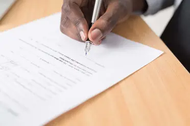 Mann notiert etwas auf Papier.