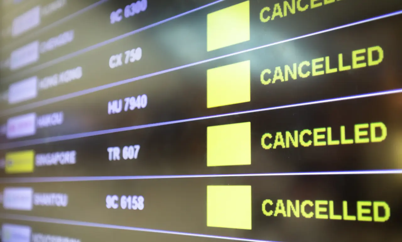 Airport departure board displaying multiple cancelled flights in yellow text.