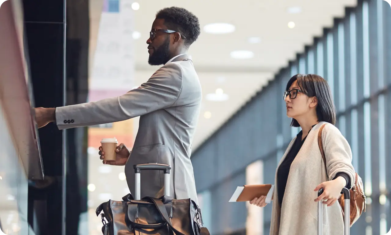 Two business people checking in at a airport counter.