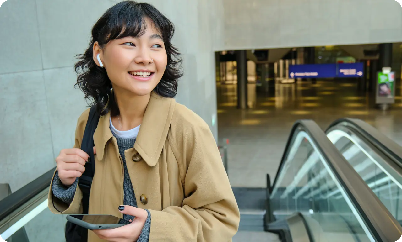 A woman walking up the stairs from a train station.