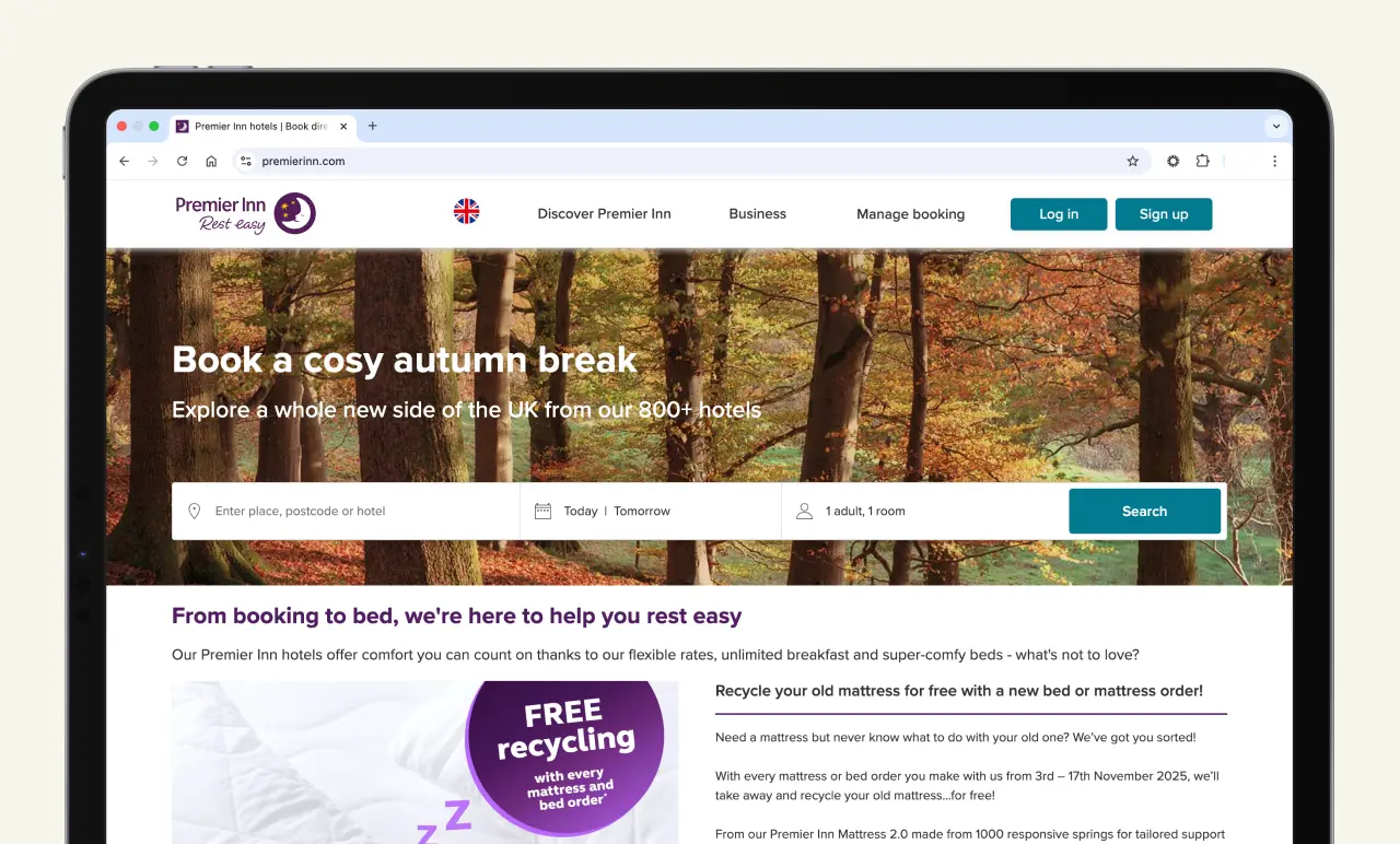 Tablet displaying Premier Inn booking website with a wooded autumn background and search bar.