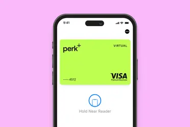 A smartphone screen displays a virtual Perk+ Visa Platinum Business card ready for contactless payment on a pink background.