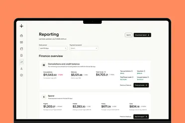 A tablet screen displaying a financial reporting dashboard with columns for cancellations, credit balance, and spend, set against an orange background.